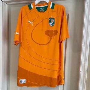 Puma bright Orange with green and white collar size large short sleeve shirt.
